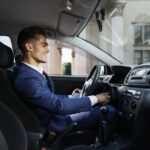 Smiling businessman sits insde the car